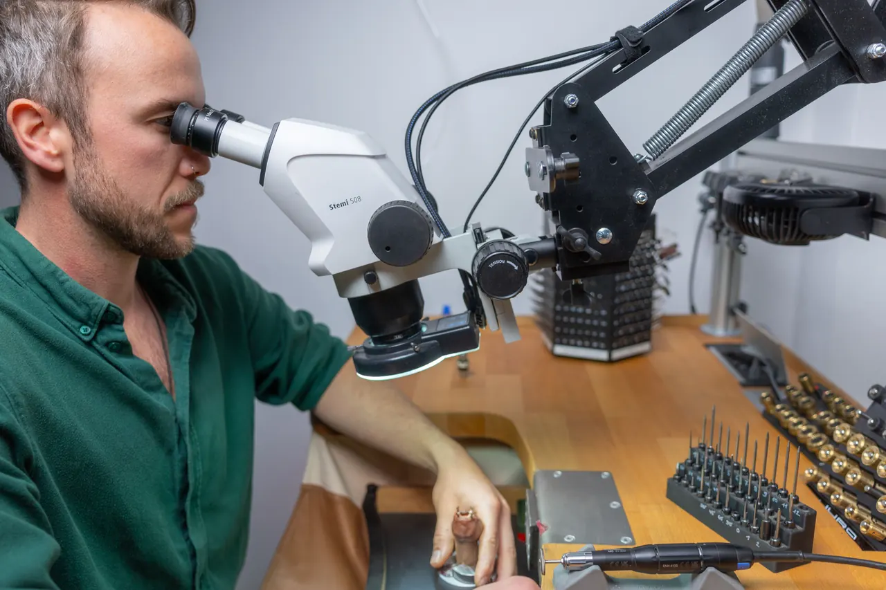 Michael Raith am Stereomikroskop in der Werkstatt